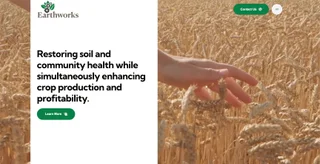 Earthworks home page — a split hero with the headline 'Restoring soil and community health while simultaneously enhancing crop production and profitability' beside footage of a hand brushing through a wheat field